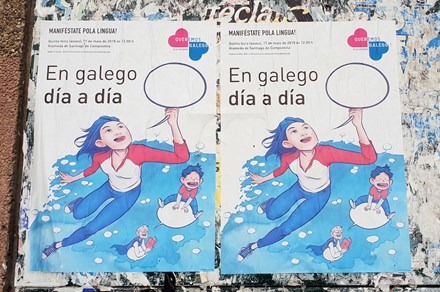 Street posters encouraging people to join the Galician language parade on May 17, 2018, organized by Queremos Galego (“We Want Galician”). The main text reads, “In Galician day by day.” 