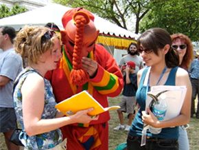 Laura Service (left) and Eleana Diaz interview an atsara masked dancer from Bhutan. Photo courtesy of Sarah Searcy
