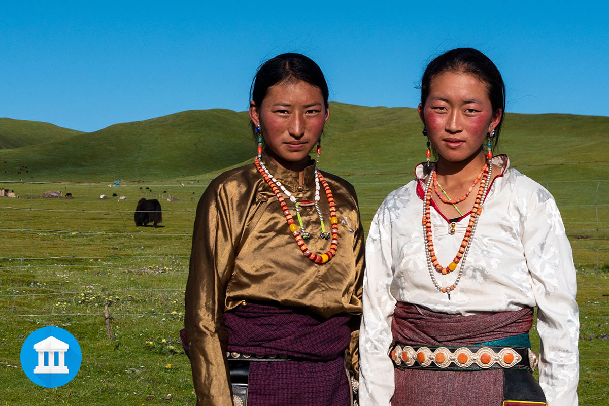 Two women standing in an open field.