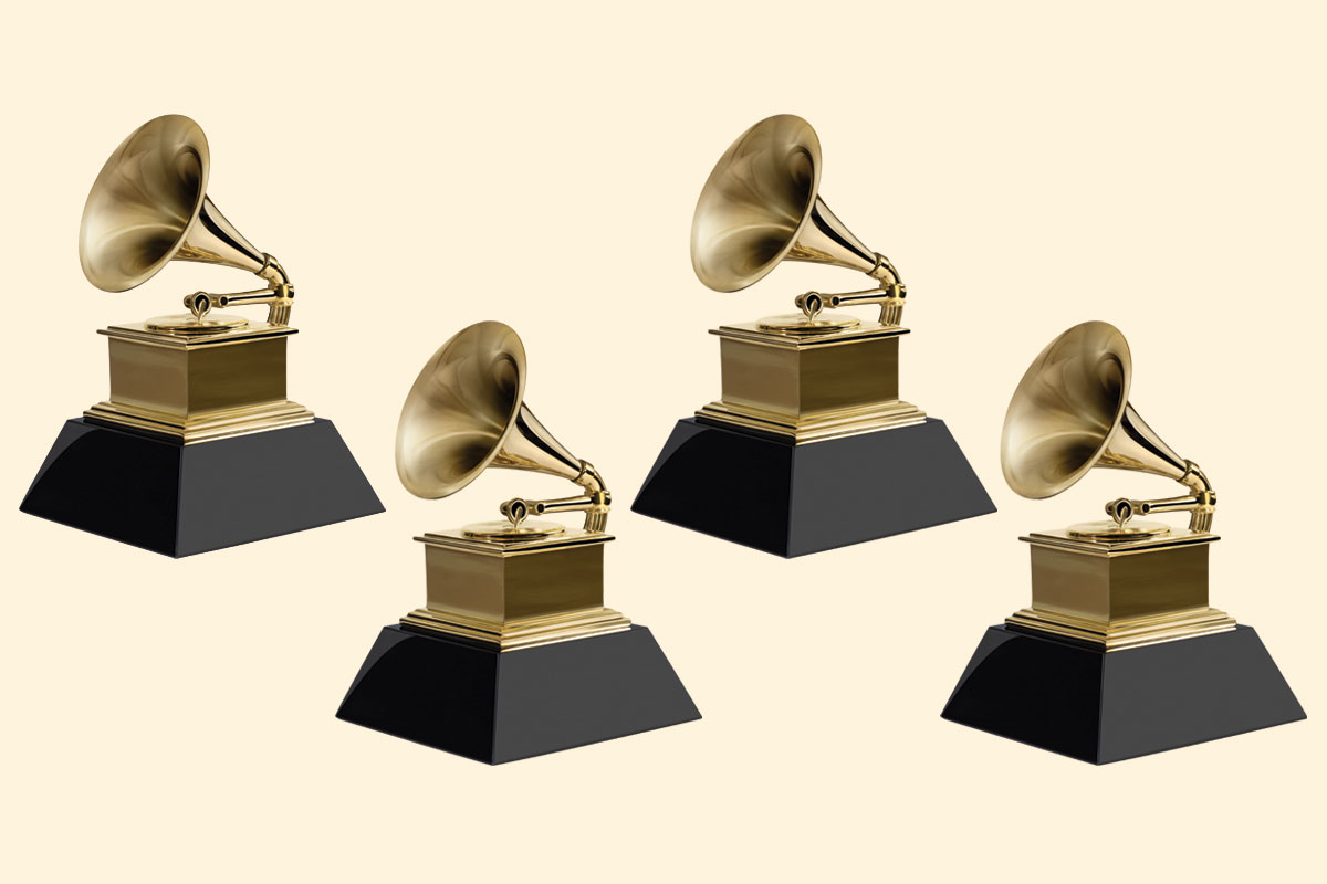 Four golden GRAMMY award statues on a yellow background.
