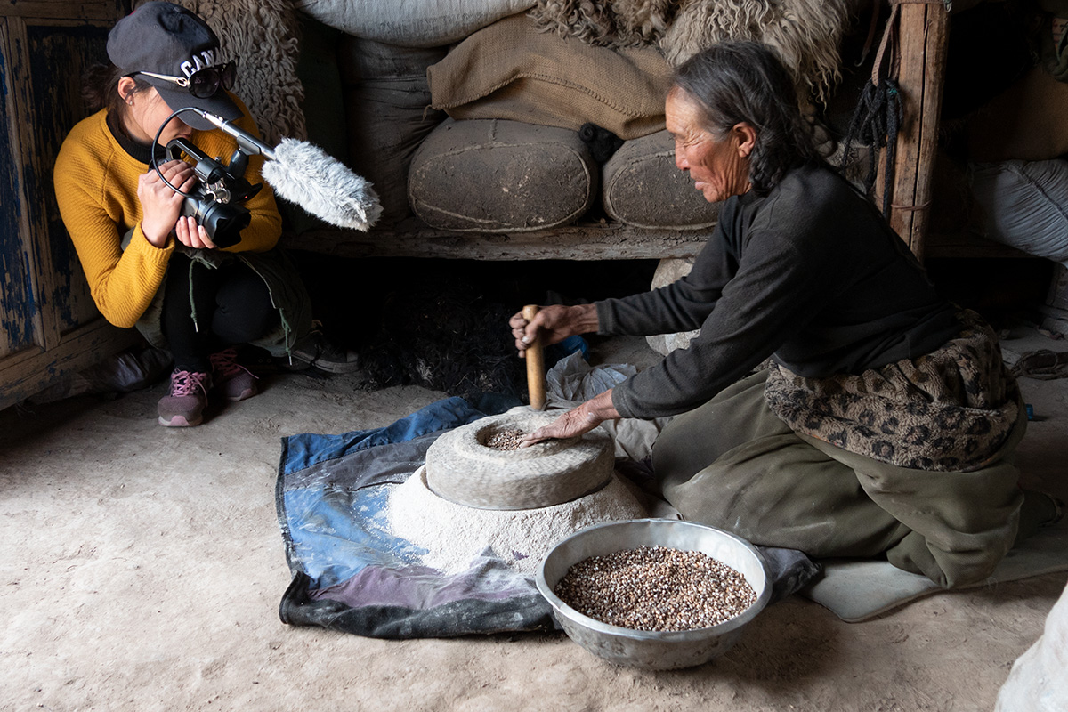 Lhamo mills tsamba (roasted flour) while Dawa Drolma films in Gangtsa village, Zhün ha County, Qinhai Province