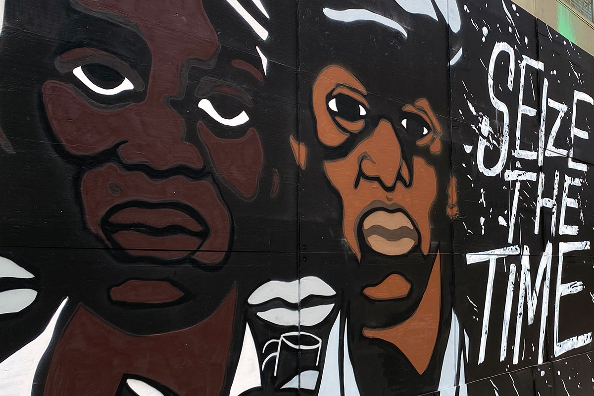 Mural of the faces of two Black men alongside the words SEIZE THE TIME.