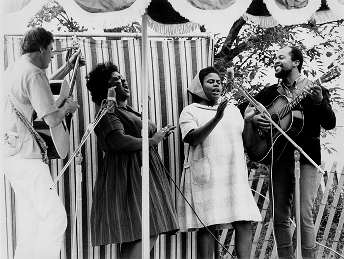 Guy Carawan, Fannie Lou Hamer, Bernice Johnson Reagon, and Len Chandler perform civil rights songs at the 1965 Newport Folk Festival. Photo by Diana Davies, Ralph Rinzler Folklife Archives