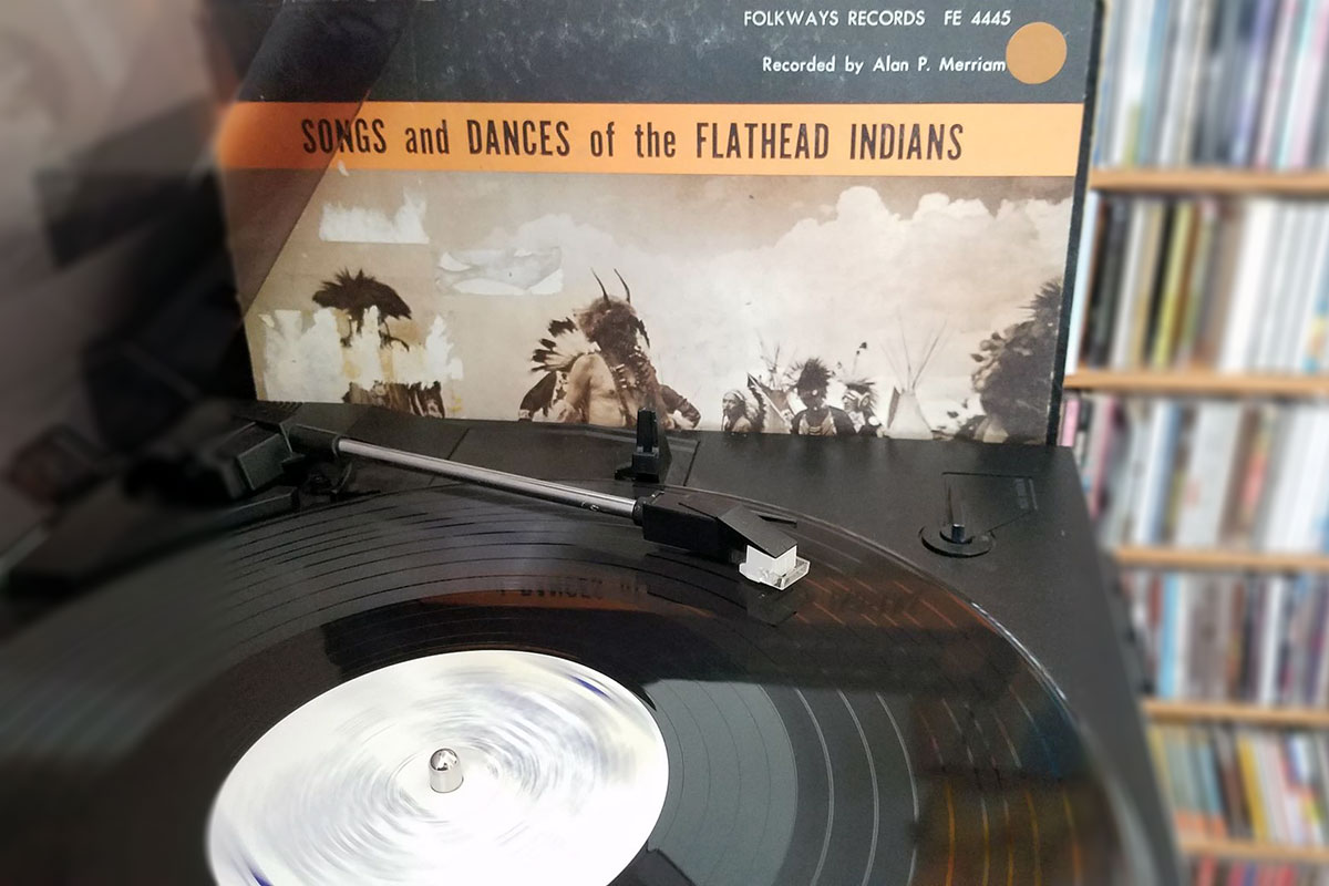 A vinyl record on a turntable, with the cover next to it: Songs and Dances of the Flathead Indians.