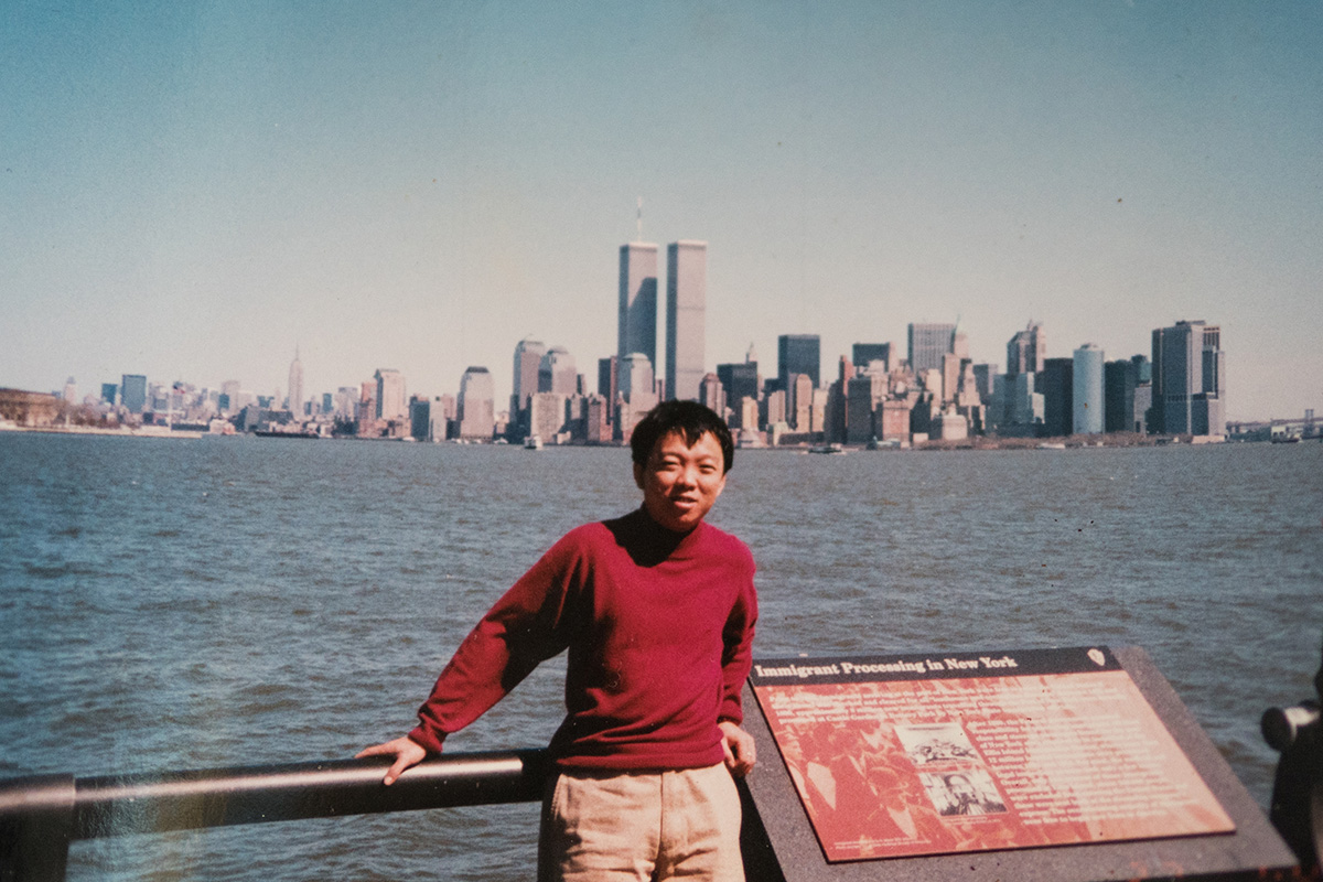 My father on Ellis Island. The sign reads, “Immigrant Processing in New York.” Photo courtesy of Shou De Zhang