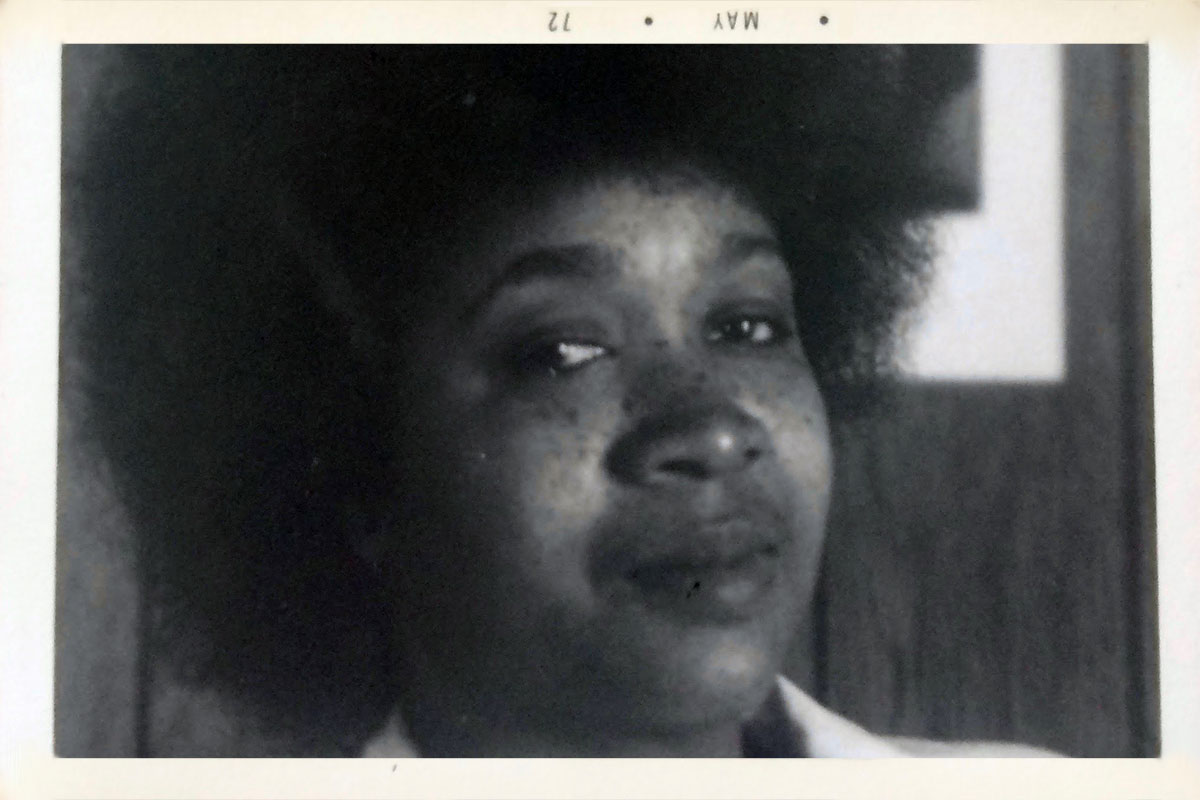 Black woman with an Afro. Black-and-white photo dated May 72 in the top border.