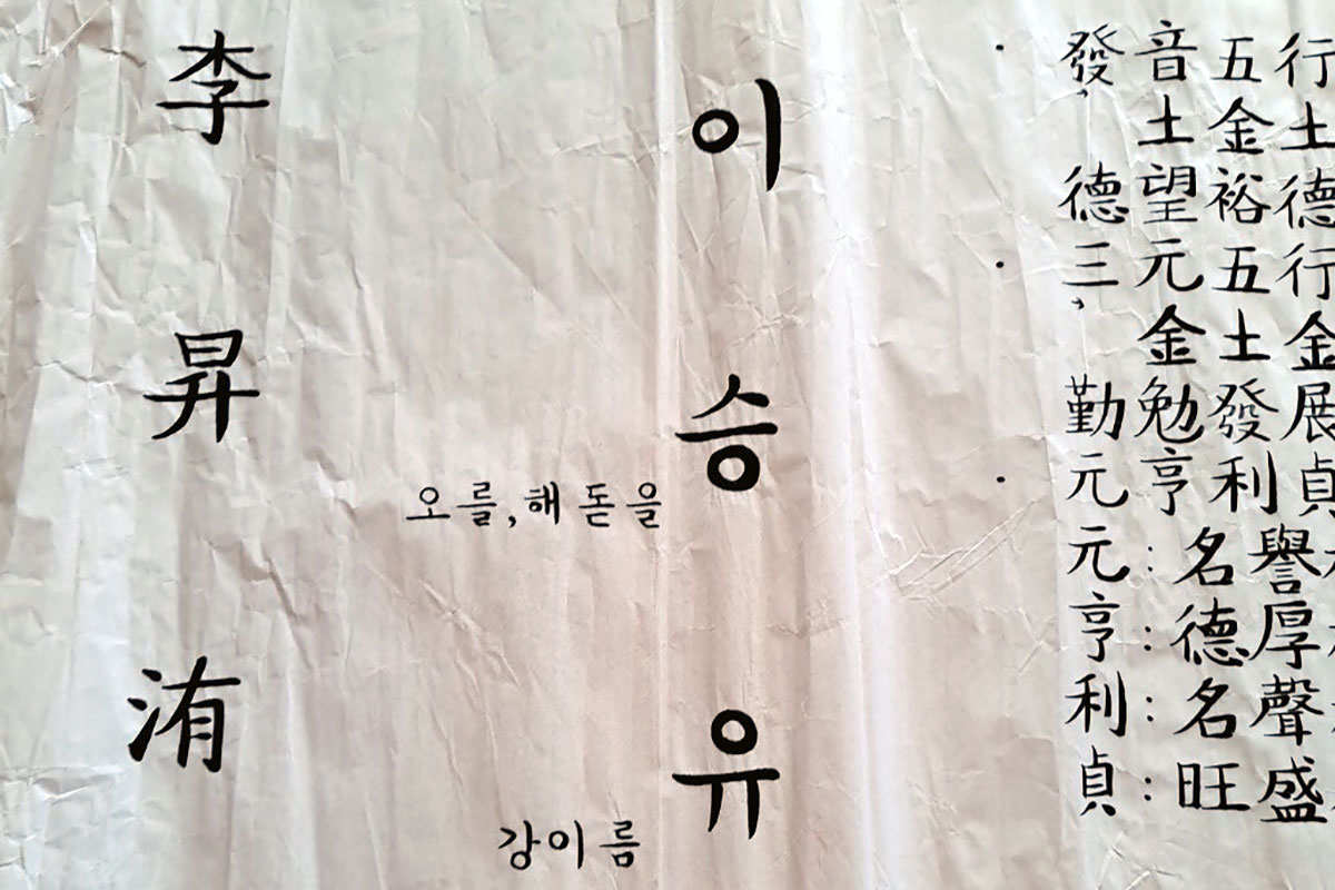 A crumpled white paper with Korean characters in black.