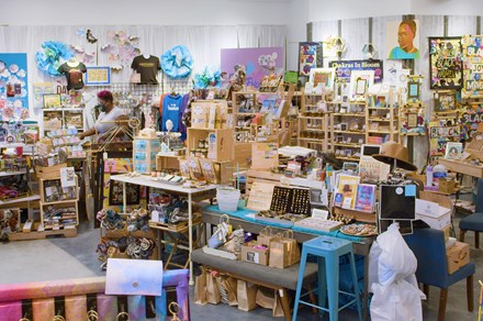 Bright interior of a store chock full of art and craft items on blonde wood shelving.