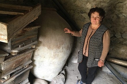 Asli Saghatelyan stands next to her father-in-law’s 240-gallon karas, a clay vessel traditionally used in Armenia, until recently, for storing and fermenting homemade wine. Photo by Karine Vann, Smithsonian