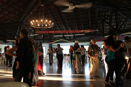 Open-air dance club, with many couples on the dance floor. Sign above reads: ESTOY EN LA MEJOR VIEJOTECA DE CALI, NUESTRA VIEJOTECA.