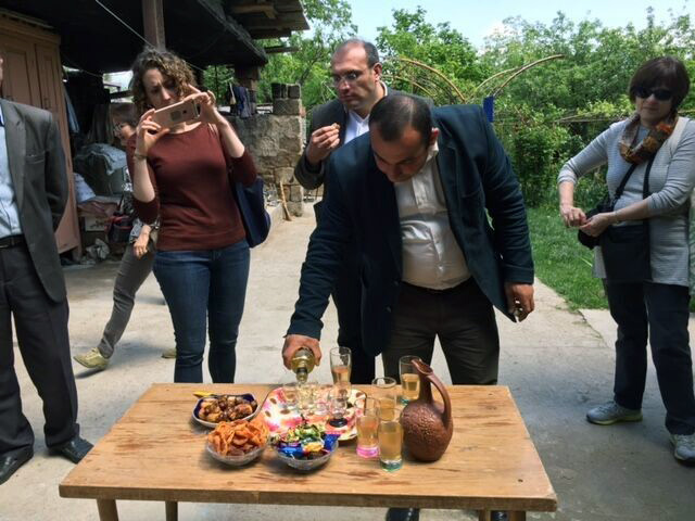 Pouring vodka for a toast alongside the "Armenian sneakers" in the bowl at the top left of the table. Photo by Diana N'Diaye